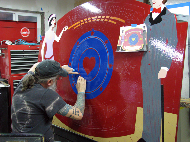 Dubh taping circle to add gold highlights to Fairbanks Distillery sign.